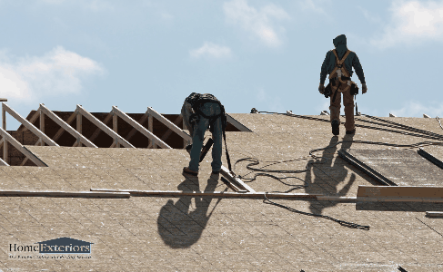 Two Roofing Contractors Are Performing Repair Work on a Residential Roof in Cleveland Heights