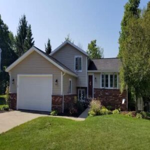Split-level suburban home with tan siding and brick base in Akron, Ohio.
