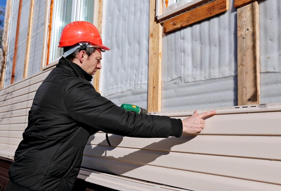 Worker installing exterior siding on a home in Northfield, OH