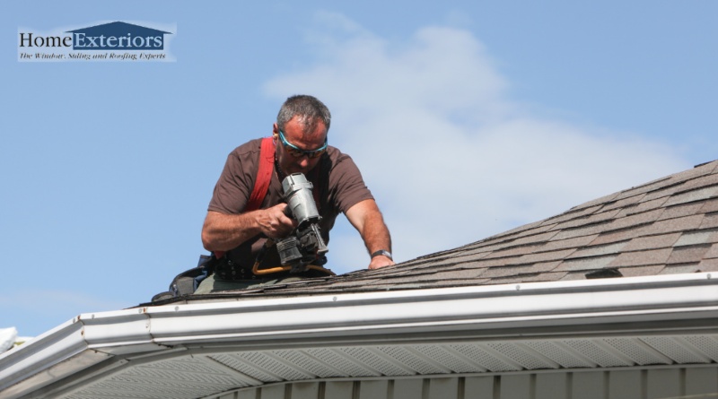 A Contractor Repairing Damaged Asphalt Shingles During an Emergency Roof Repair Service in Parma, OH