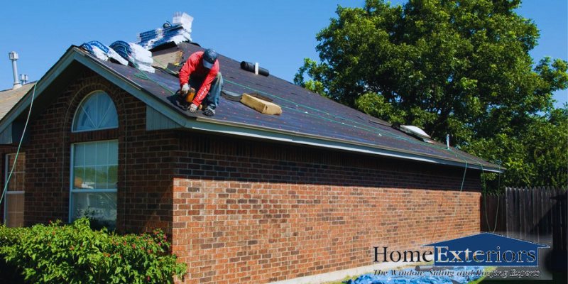 Contractor Repairing a Residential Roof near the Eaves of a Brick Home in Broadview Heights, OH